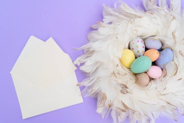 Paskalya sahnesinde menekşe arkaplan üzerinde renkli yumurtalar, kopyalama alanı