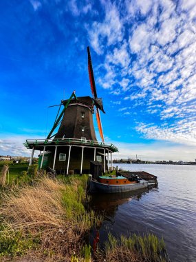 Hollanda 'nın geleneksel yel değirmeni Zaanse Schans yaz günbatımında su üzerinde, Hollanda