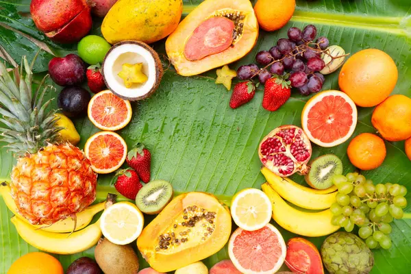 Yeşil yaprağın üzerinde tropikal meyve karışımı ve fotokopi alanı