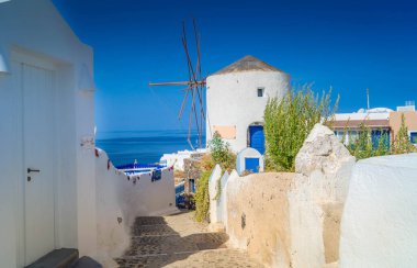 Beyaz yel değirmenli geleneksel manzara, Yunanistan 'ın Santorini kentindeki beyaz Yunan köyü