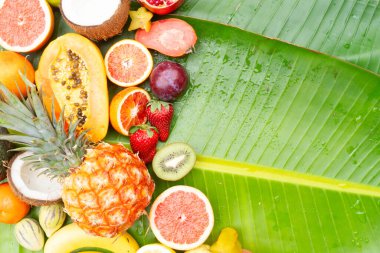 Yeşil yaprağın üzerinde tropikal meyve karışımı ve fotokopi alanı