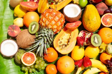 Yeşil yaprağın üzerinde tropikal meyvelerin yaz karışımı