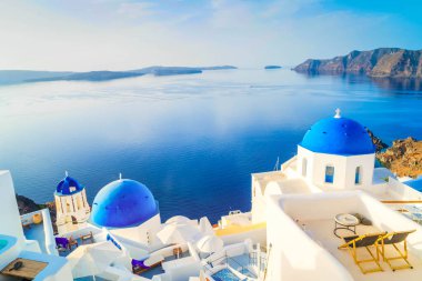 Beyaz kilise çan kubbesi, parlak mavi kubbeler ve deniz manzaralı volkan kalderası, Yunanistan 'ın Santorini adasının güzel detayları