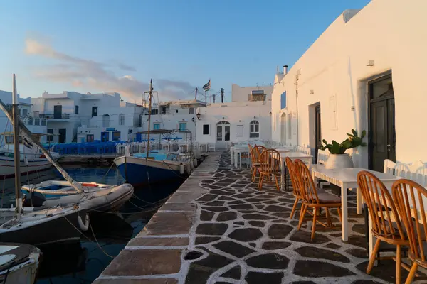 Naoussa köyü limanında demirli tekneler ve mavi kafe masaları
