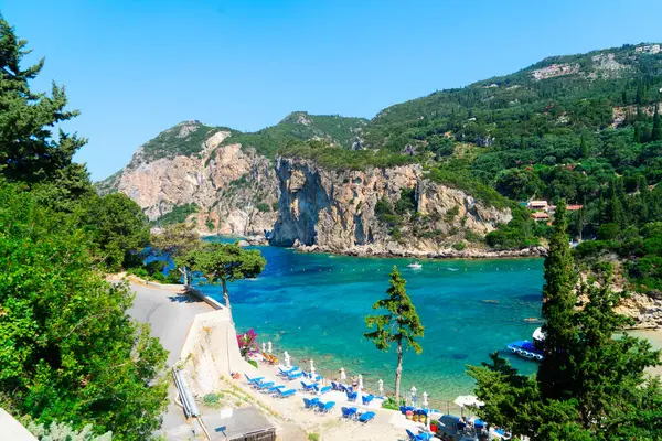 Paleokastritsa plaj koyunda güneşli yataklar ve Yunanistan 'ın Korfu kentinde İyon denizi açık suları