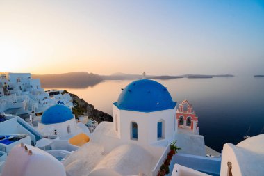 Geleneksel Yunan köyü Santorini 'nin Oia' sı, mavi kilise kubbeleri ve sabah ışığında köy çatılarıyla Yunanistan