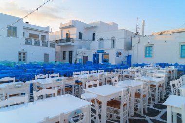 Naoussa köyü limanında demirli tekneler ve mavi kafe masaları