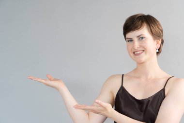 Gri arka planda yaşayan mutlu genç kız.