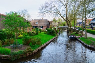 Hollanda kırsalının geleneksel küçük bir kasabası. Giethoorn, Hollanda 'da kanal ve köprü manzaralı.
