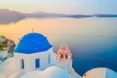 Geleneksel Yunan köyü Santorini 'nin Oia' sı, mavi kilise kubbeleri ve sabah ışığında köy çatılarıyla Yunanistan