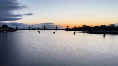 Hollanda 'nın geleneksel yel değirmeni Zaanse Schans yaz günbatımında su üzerinde, Hollanda