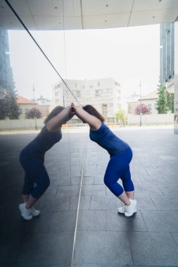 Kadın ve spor, temiz havada kilo vermek için egzersiz. Yorgun 40 'lı yaşlardaki kadın şehir parkında egzersiz yapıyor.