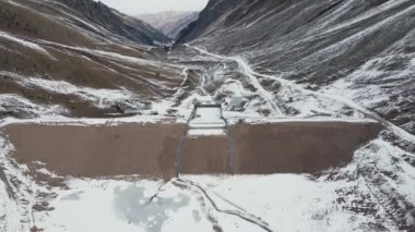 Hava aracı Almaty Kazakistan 'daki dağ vadisinde kar zirvesi yakınlarındaki bir baraj ve nehrin görüntüsünü ortaya çıkardı.