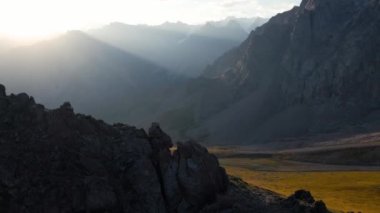 Hava aracı, Almaty Kazakistan 'daki dağ vadisinde kaya duvarı ve parlayan güneşin yörünge görüntüsünü ortaya çıkardı.