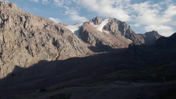 空中ドローンの風景は アルマトイカザフスタンのShymbulak山リゾートの山の谷で氷河と雪のサミットのショットを明らかに — ストック動画
