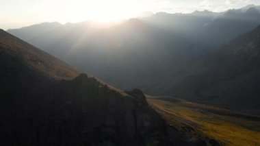 Hava aracı, Almaty Kazakistan 'daki dağ vadisinde kaya duvarı ve parlayan güneşin yörünge görüntüsünü ortaya çıkardı.
