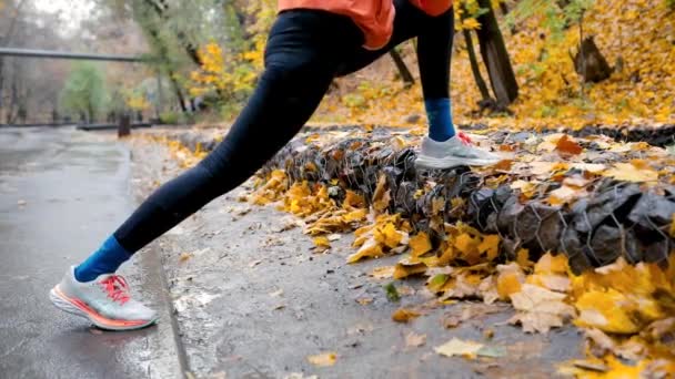 Löpare Kvinna Orange Jacka Gör Uppvärmningsrörelser Innan Hon Springer Och Videoklipp