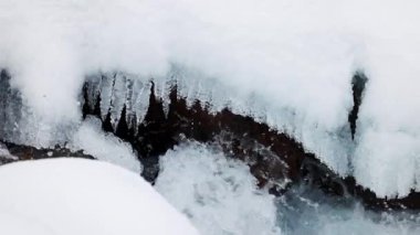 Mavi su nehri taşların arasından akar kış vakti dağlarda kar ve buzla birlikte yavaşça yaklaşır.