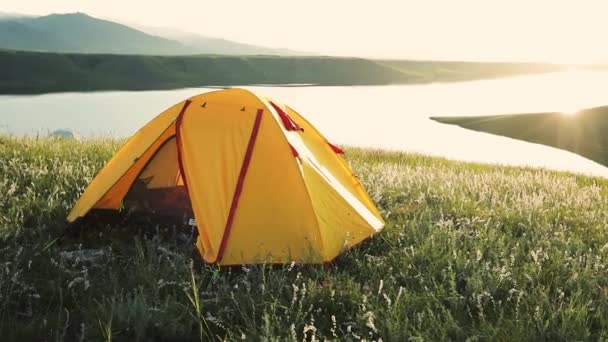 スローモーション屋外レクリエーションのコンセプトで湖の近くの山の中で黄色のキャンプ観光テント — ストック動画