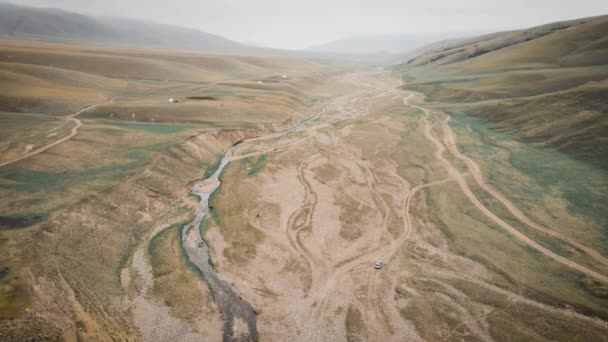 在哈萨克斯坦Assy高原中亚河流附近山区 空中越野车沿着砾石路行驶 — 图库视频影像
