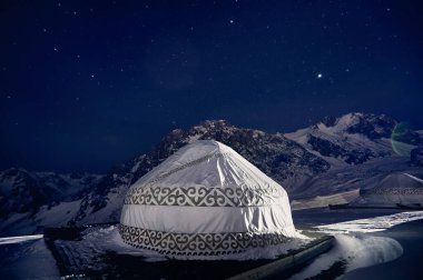 Kazakistan, Almaty 'deki Shymbulak kayak merkezindeki Yurt ya da Yurta göçebe evi. Dağların zirvesinde yıldızlı kış gecesi astrofotoğrafçılığı