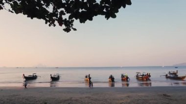 Tayland 'da sabah saatlerinde Ao Nang' ın tropikal sahillerinde uzun kuyruklu teknelerle hareket eden insanların zamanaşımı. Seyahat tutkusu kavramı.