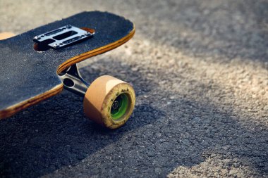 Skate board longboard at mountain asphalt road close up shot at of tail with wheels detail