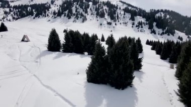 Almaty Kazakistan 'daki kışlık dağ vadisinde, kar zirvesinde buzla kaplı küçük bir evin hava aracı görüntüsü.