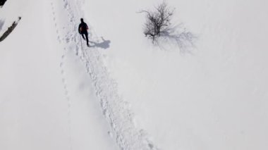İnsansız hava aracı Almaty Kazakistan 'daki kar vadisinde sırt çantasıyla gezen bir adamın resmini çekti.