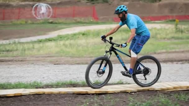 青いシャツを着たMtbバイカーとエンデューロ山道公園に乗るヘルメット 山の中をマウンテンバイク下り — ストック動画