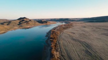 İHA, güney Kazakistan 'da gün batımında Ili nehri ve bahar bozkırlarını görüntüledi. Güzel doğa manzarası