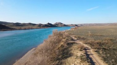 İHA, güney Kazakistan 'da gün batımında Ili nehri ve bahar bozkırlarını görüntüledi. Güzel doğa manzarası