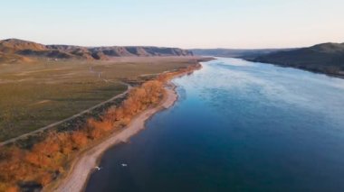 İHA, güney Kazakistan 'da gün batımında Ili nehri ve bahar bozkırlarını görüntüledi. Güzel doğa manzarası ve uçan kuşlar