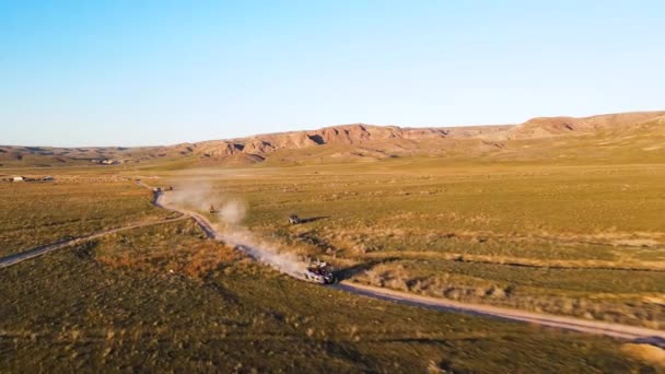 카자흐스탄의 노을에 근처의 먼지많은 도로에서 고속으로 주행하는 모습을 공중에서 촬영했다 — 비디오