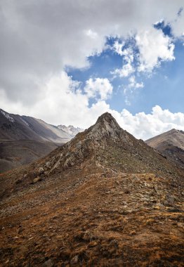 Almaty Kazakistan 'daki Tien Shan Dağları' ndaki mavi bulutlu gökyüzüne karşı dağ manzarası vadisi.