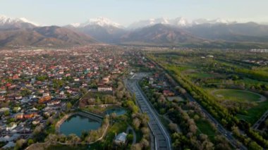 Büyük Almaty Nehri 'nin hava aracı manzarası ve arka planda kar dağları manzaralı evler Kazakistan' ın Almaty şehrinde.