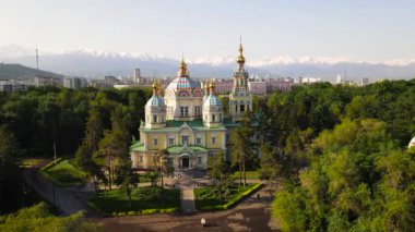 Yükseliş Katedrali 'nin hava aracı panoraması Rus Ortodoks kilisesi ve arka plandaki kar dağları Kazakistan' ın Almaty şehrinin Panfilov Parkı 'nda.