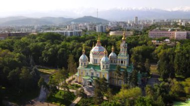 Yükseliş Katedrali 'nin hava aracı panoraması Rus Ortodoks kilisesi ve arka plandaki kar dağları Kazakistan' ın Almaty şehrinin Panfilov Parkı 'nda.