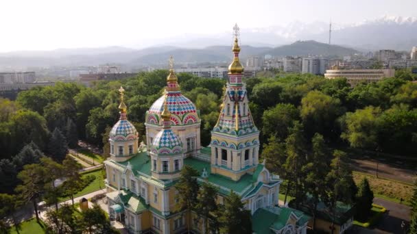 哈萨克斯坦阿拉木图市Panfilov公园背景下的阿森松大教堂俄罗斯东正教教堂和雪山的无人驾驶飞机全景 — 图库视频影像