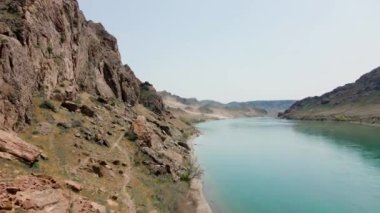 İHA, Ili Nehri 'nin bahar bozkırını ve Güney Kazakistan' da kırmızı tişörtlü iki patika koşucusunu görüntüledi..