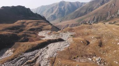 Kazakistan 'da sonbahar zamanı, kar buzulu ve tepelerle dağların güzel manzarası. Açık hava ve yürüyüş konsepti, insansız hava aracı görüntüsü.