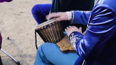 Geleneksel Asya Elbiseli Adam, Kazakistan Orta Asya 'daki etnik festivalde akustik davul çalıyor.