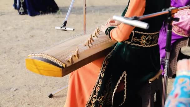 Kobieta Tradycyjnej Azjatyckiej Odzieży Gra Instrumencie Smyczkowym Festiwalu Etnicznym Kazachstanie — Wideo stockowe