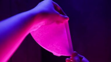 Kahve filtresi tutan kadın baristanın dikey videosu neon ışığı altında demleniyor. Yaratıcı pembe mavi renk arkaplanı.