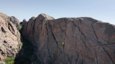 Atina 'nın yeşil gömlekli insansız hava aracı Orta Asya, Kazakistan' daki Ili nehrindeki yüksek kayaya tırmanıyor.