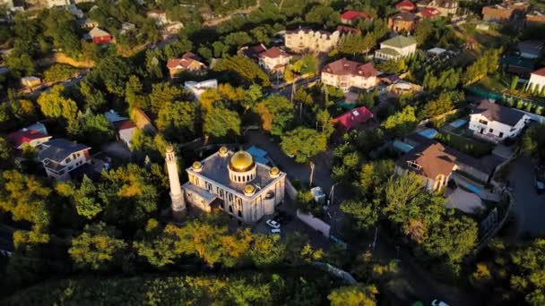 カザフスタンのアルマトイの家に対して日没時に黄金のドームとモスクの空中ドローンショット — ストック動画