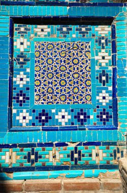 Shahi Zinda 'nın güzel tarihi mezarlığının duvarında bulunan mozaik, Semerkant, Özbekistan' daki mavi ve turkuaz taştan mozaik anıtlarla süslenmiş..