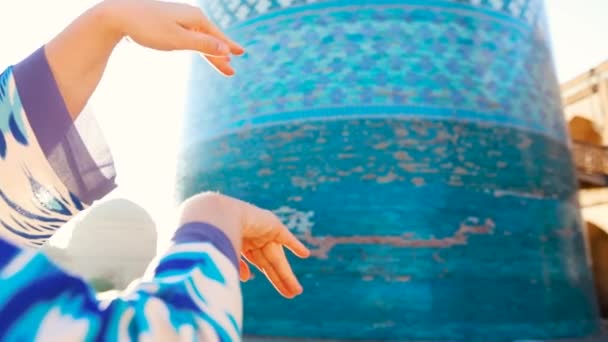 乌兹别克斯坦伊昌卡拉古镇Khiva市Minaret Kalta小东方建筑附近 一位身着民族服装 身着蓝色图案舞姿的女性慢动作女子手牵着手跳舞 — 图库视频影像