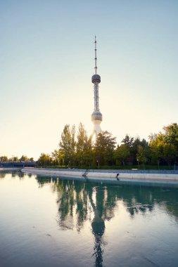 Taşkent Televizyon Kulesi Toshkent Teleminorasi, Özbekistan 'da gün batımında parkın yakınındaki nehre yansıdı.