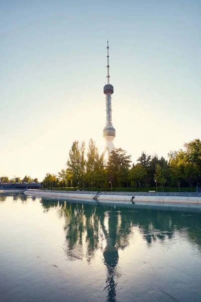 Taşkent Televizyon Kulesi Toshkent Teleminorasi, Özbekistan 'da gün batımında parkın yakınındaki nehre yansıdı.